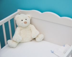 Białe łóżeczko dla niemowlaka.